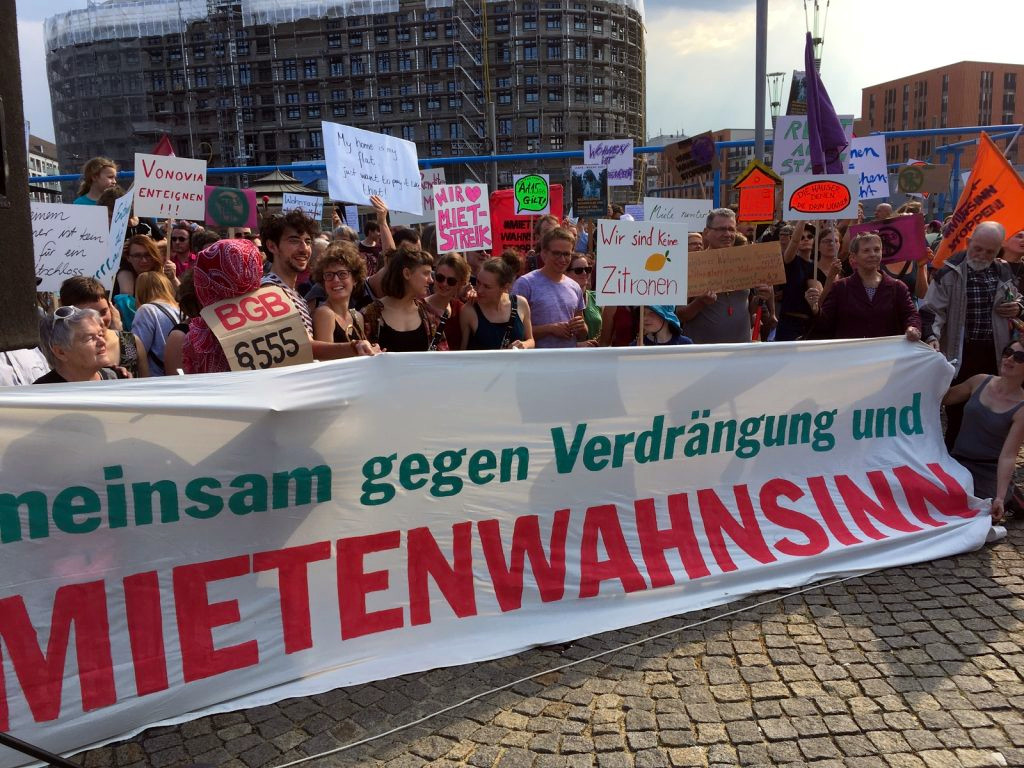 Menschenmenge hinter Transparant mit der Aufschrift: Gemeinsam gegen Verdrängung und Mietenwahnsinn.